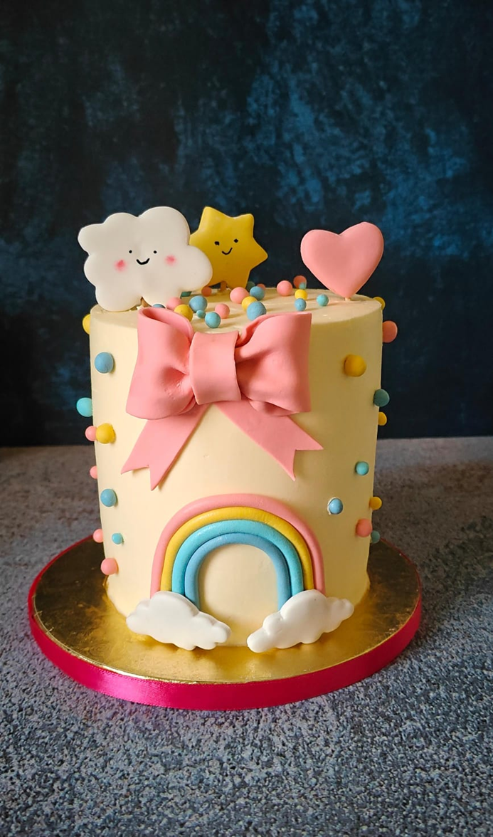 Rainbow cloud birthday cake with bow and fondant details for kids - Vivante Patisserie