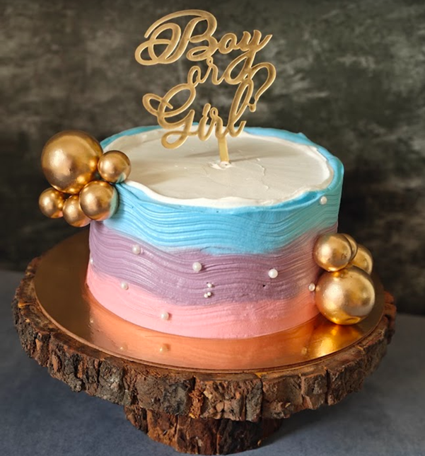 Pastel ombre gender reveal cake with gold spheres on wood slice - Vivante Patisserie